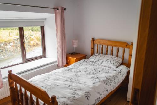 a bedroom with a bed and a window at Jack's House in Glenties