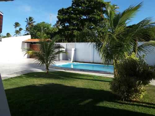 einen Pool in einem Garten mit zwei Palmen in der Unterkunft Casa no cumbuco in Caucaia