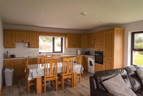 a kitchen with wooden cabinets and a table and chairs at Jack's House in Glenties