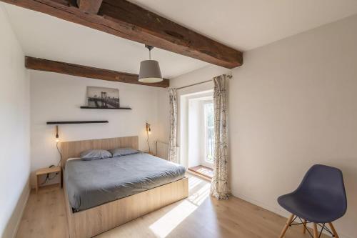 a bedroom with a bed and a blue chair at Le Grand Launay in Pacé