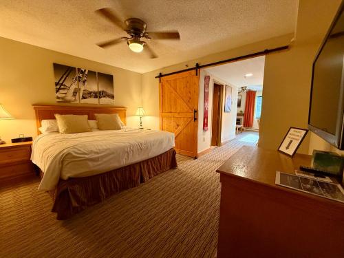 Un dormitorio con una cama y un televisor de pantalla plana. en Grand Lodge Crested Butte, en Crested Butte