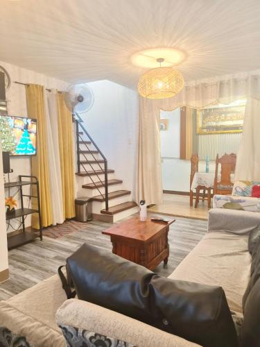 ein Wohnzimmer mit Sofa und Tisch in der Unterkunft Balai Hermioni in San Pablo City