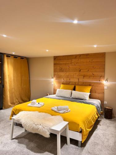 a bedroom with a large yellow bed with a wooden headboard at Gîte L'Écureuil - Sauna & Bain Nordique - Nature in Colroy-la-Roche
