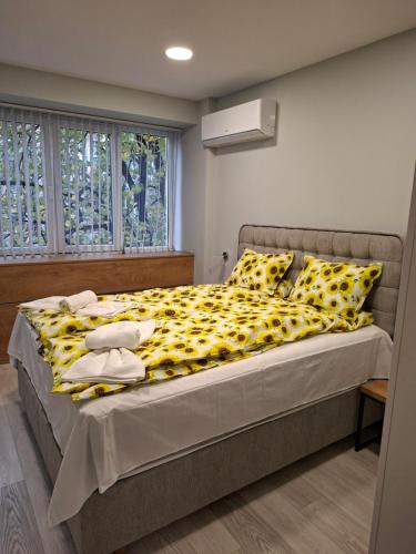 a bedroom with a bed with a yellow and black blanket at Number 1 in Ruse