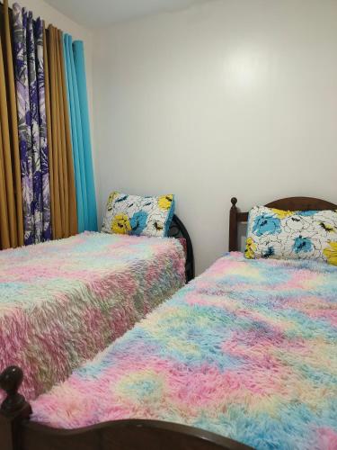 zwei nebeneinander stehende Betten in einem Schlafzimmer in der Unterkunft Balai Hermioni in San Pablo City