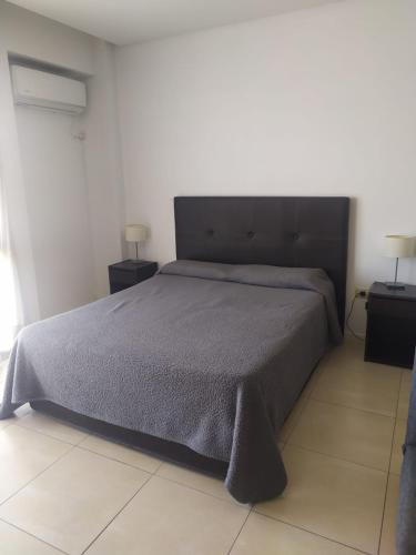 a bedroom with a large bed with two night stands at NORDELTA BAHIA GRANDE Monoambiente con cochera in Benavídez