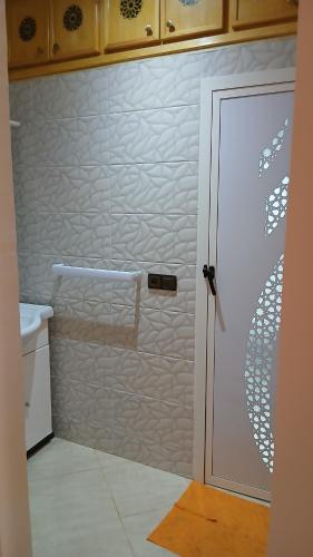 Un baño con ducha con puerta de cristal en Appartement, en Chichaoua