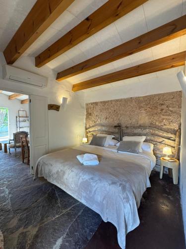 a bedroom with a large bed with a stone wall at Menorca Agroturismo Llimpet in Alaior