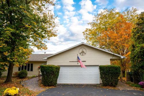 a house with an american flag on the garage at Lake Orchard View- 8 BR with Lake Access and Fire Pit in Teall Beach