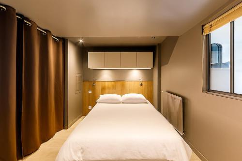 ein Schlafzimmer mit einem großen weißen Bett und einem Fenster in der Unterkunft Appartement entier T2 proche gare de Cergy préfecture in Cergy