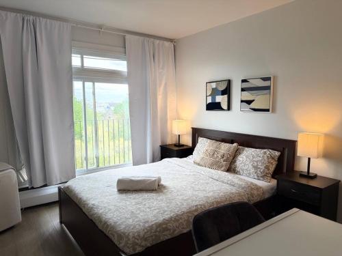 a bedroom with a bed and a large window at McGill Les petits studios in Montréal