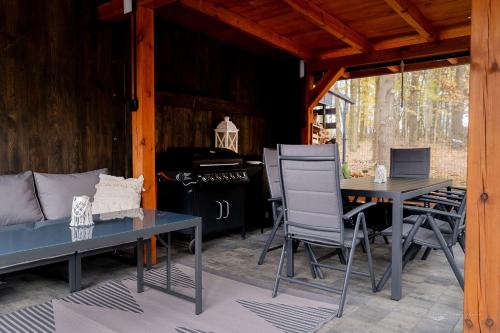 a patio with a table and chairs and a stove at Domek w Lelewie in Lelewo