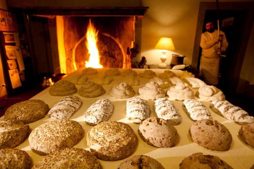 a table full of pastries with a fireplace in the background at Agriturismo Cascina Caremma in Besate