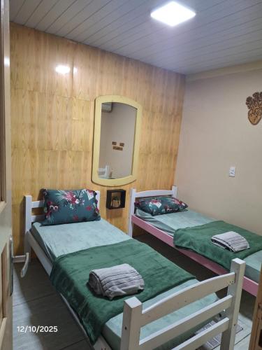 two beds in a room with a mirror at Recanto Morada Amazônica in Manaus