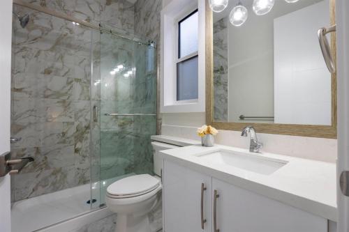 a bathroom with a toilet and a sink and a shower at Excellent Place to Stay in Coquitlam