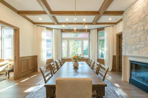 een eetkamer met een tafel en een open haard bij Samson House in Revelstoke