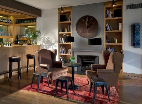 a bar with chairs and a fireplace and a clock at Starhotels Tuscany in Florence