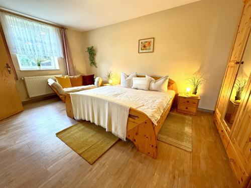 a bedroom with a large bed and a couch at BAUERNHAUS KRULL App 03 in Althagen