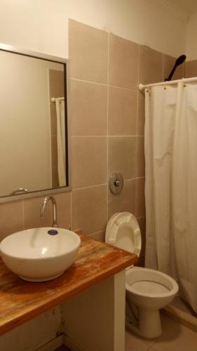 a bathroom with a sink and a toilet and a mirror at HOTEL RESTAURANTE Ruta 66 in Paso de los Libres