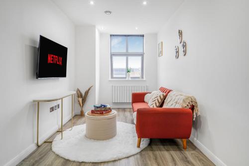 a living room with a red chair and a table at The Velvet Nest 2BR 2BA in Leicester