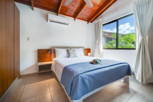 a bedroom with a bed and a large window at Villaggio 6 Parque al Lago, Playa Potrero in Potrero