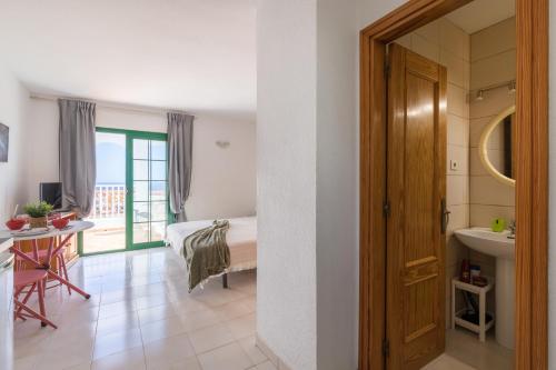 a room with a bed and a sink and a bathroom at Caleta Paraiso Sea View 137 in Costa de Antigua