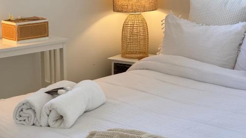 a bedroom with a white bed with a stuffed animal on it at Palacete Beach Resort in Culburra Beach