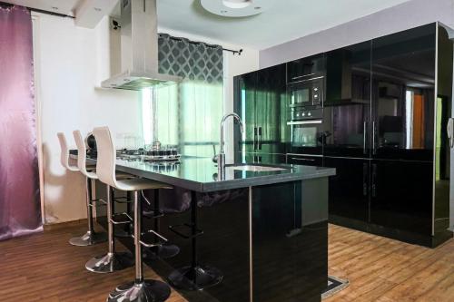 a kitchen with a sink and a counter with stools at L'Andalou -3 bedrooms with Parking in Downtown in Kenitra