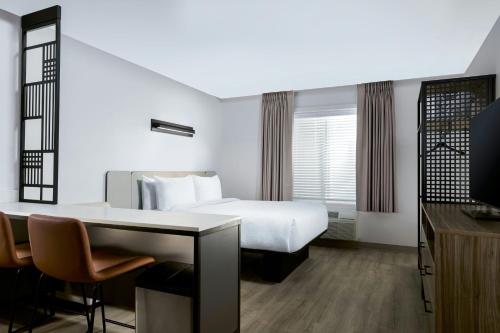 ニューナンにあるStudioRes by Marriott, Newnanのベッドと机とテレビがあるホテルの部屋