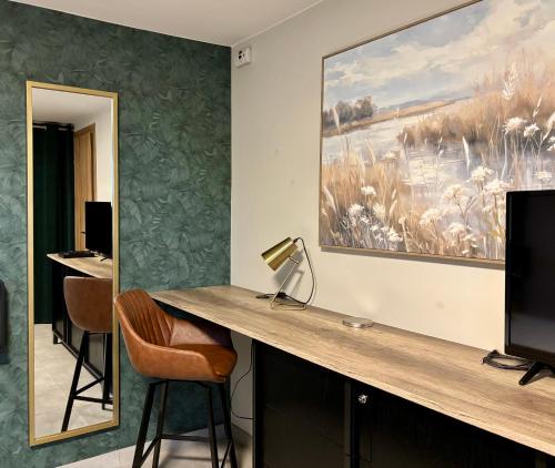 a desk with a lamp and a painting on the wall at Élégant 2 pièces au calme, axe Metz-Luxembourg in La Celle-sous-Gouzon