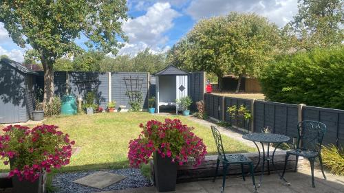 a garden with a table and chairs and flowers at Lincoln Cathedral Retreat in Scampton