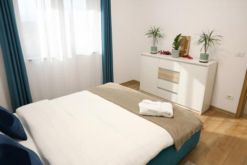 een slaapkamer met een bed met twee handdoeken erop bij Hushu Apartment in Giroc