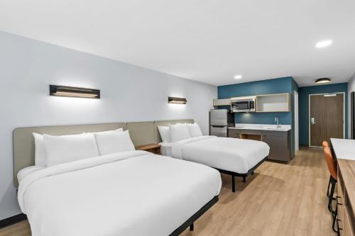 a hotel room with two beds and a kitchen at StudioRes by Marriott Newnan in Newnan