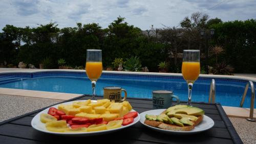 une table avec deux verres de jus d'orange et une assiette de nourriture dans l'établissement Casa Honiol, private and spacious villa with sea views, à Cala'n Porter