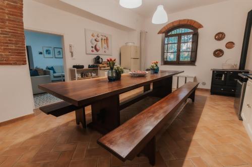 een keuken met een houten tafel en een bank bij DONNA LAURA - Holiday Home in Arezzo