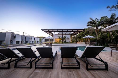 a group of chairs sitting next to a swimming pool at Refúgio Amazônico com Piscina e Natureza in Manaus