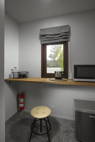 a kitchen with a counter with a stool and a window at Baan Chang Sanctuary in Laguna Phuket