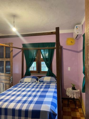 a bedroom with a bed with a blue and white checkered blanket at Casa Maria Bonita in Aracati