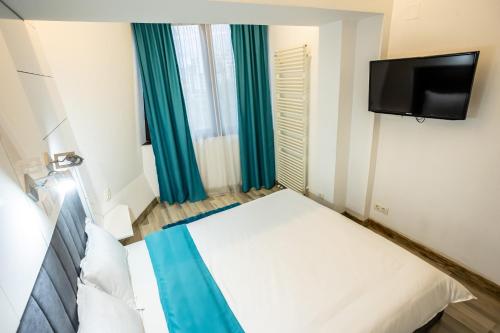a small bedroom with a bed and a tv at Mara Park in Baia Mare