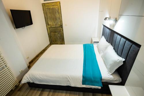 a bedroom with a bed with a blue blanket on it at Mara Park in Baia Mare
