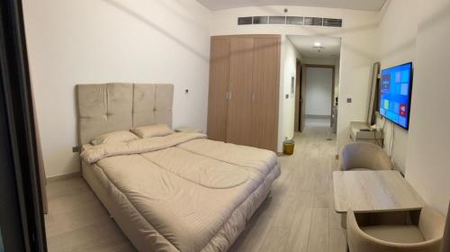 een slaapkamer met een groot bed en een tafel bij Deluxe studio water front in Dubai