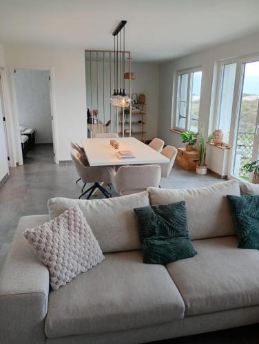 a living room with a couch and a table at Duinzicht in Westende-Bad