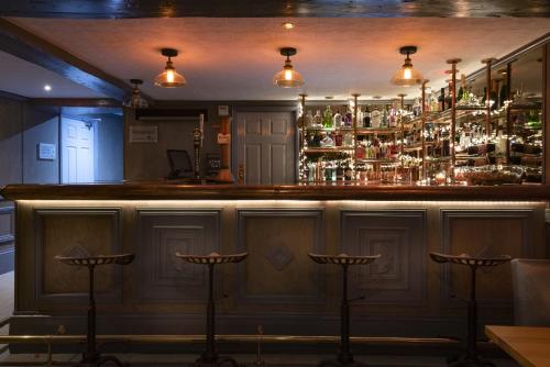 ボストンにあるTwenty Hotel and Barのバーの前にいくつかの椅子が置かれたバー