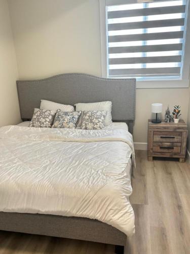 a bedroom with a large bed and a window at Prince George Cozy Suite in Prince George