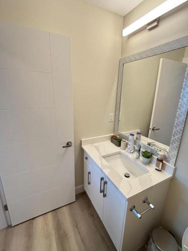 a bathroom with a sink and a mirror at Prince George Cozy Suite in Prince George