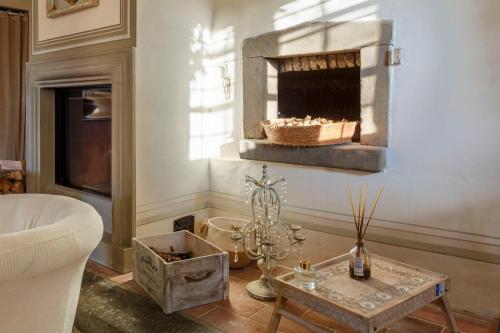 Una sala de estar con chimenea y una mesa. en Villa Ridente - Elegance and views of Florence, en Settignano