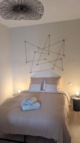 a bedroom with a bed with two towels on it at L'alcôve - appartement moderne et spacieux - proche gare - centre historique - WiFi - Clim in Béziers