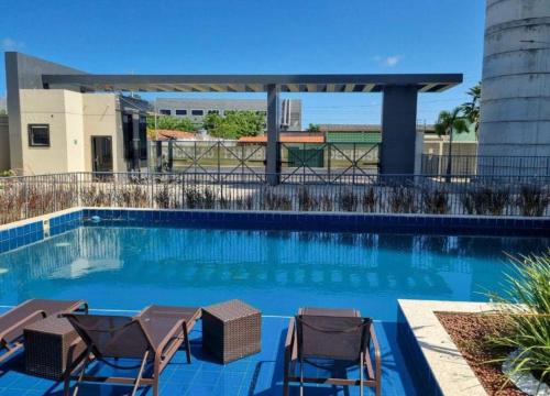 a swimming pool with two chairs and a swimming pool at (208)Apt de luxo com varanda 2 quartos 1km do Mar in Tambauzinho