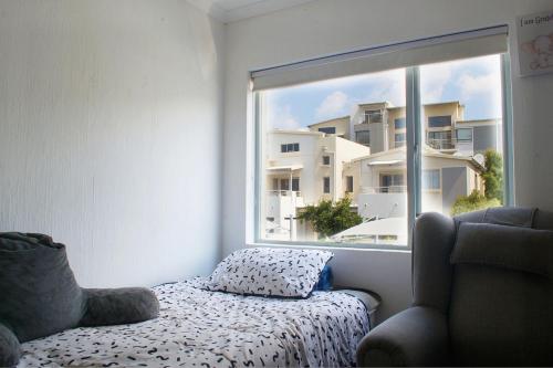 Un dormitorio con una cama y una ventana grande en Serene escape in Johannesburg, en Fourways