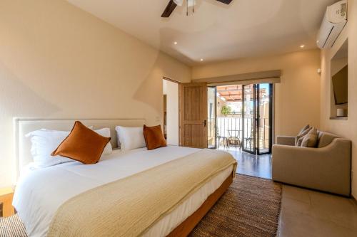サンミゲル・デ・アジェンデにあるDesigner Retreat in Centro Heated Pool & Viewsの大きな白いベッドと椅子のある寝室